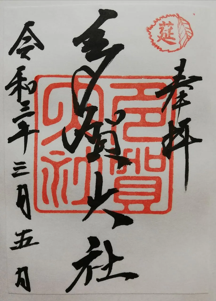 A goshuin with black brush lettering over a large red seal and a small red seal at the corner.