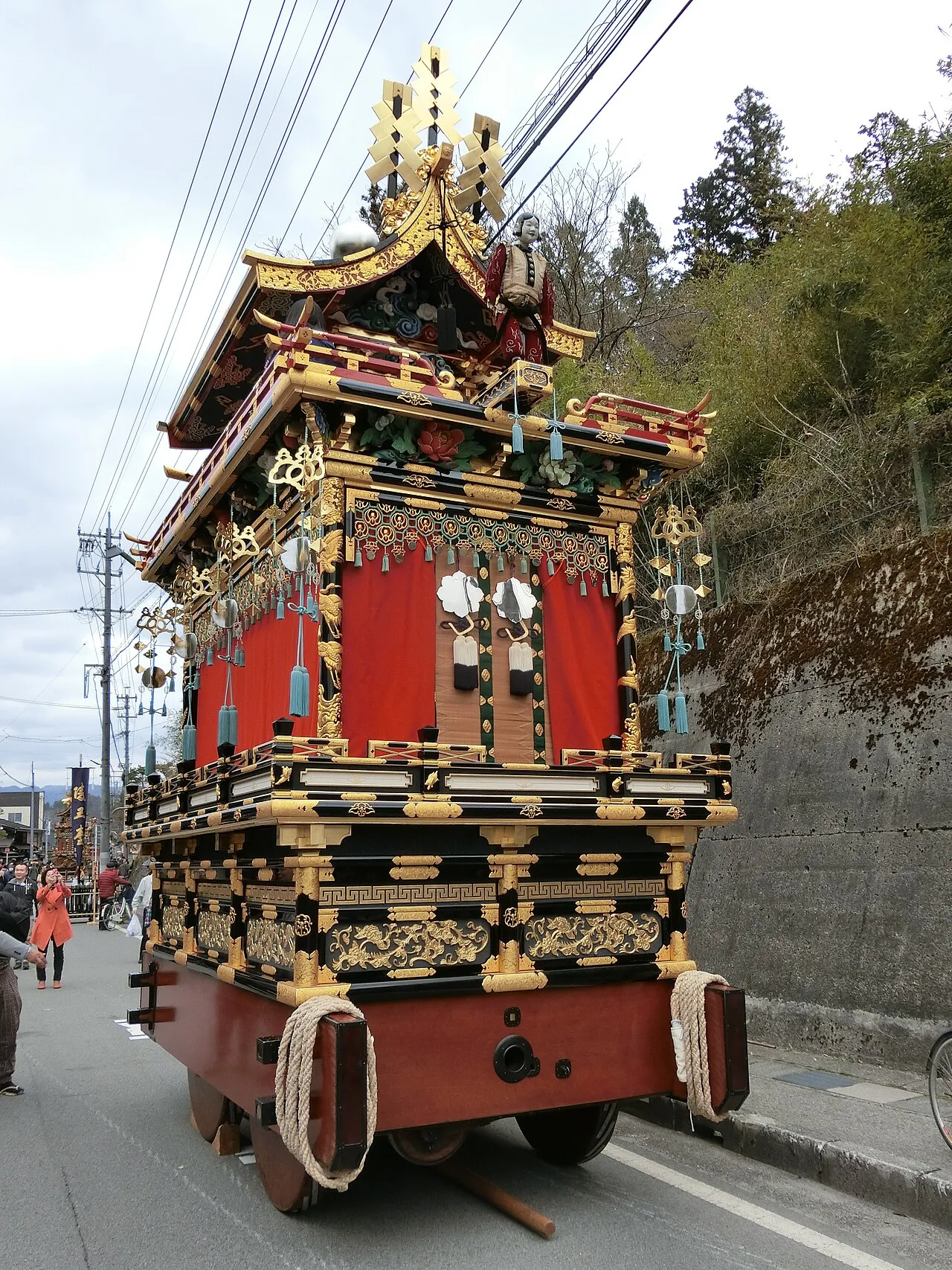 The tall red and gold Kongō-tai float in a Takayama street.
